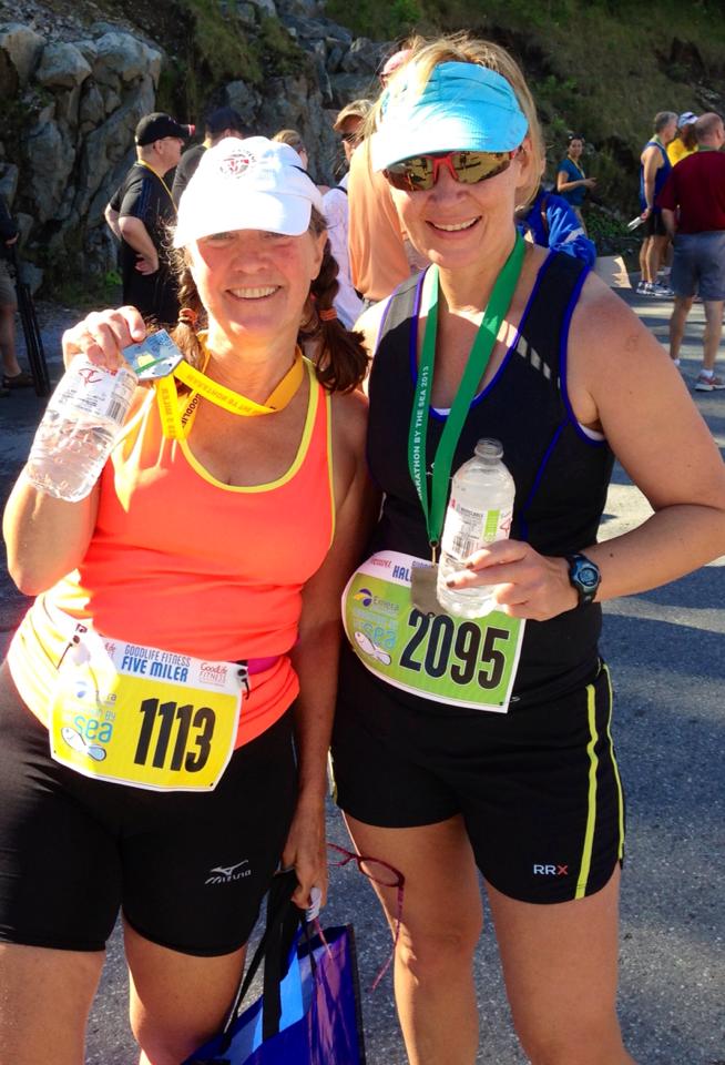 Joy Durdan, right, celebrates with a friend in the finish area following the 2013 Marathon By The Sea.