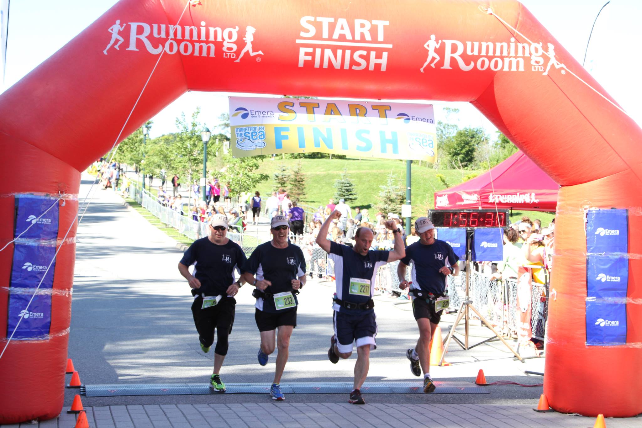 Alan Theal, second from left and his Amherst Striders running partners -Rick McKenney, Tim Parker and Ken MacKenzie, celebrate as they cross the finish line at the 2013 Marathon By The Sea.