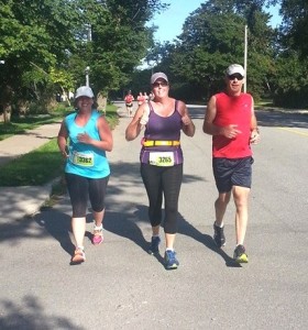 Rob Long, right, went back on course after his race and ran with his friend Elaine Boulanger, centre, in her first half marathon. Also pictured is Erin Toole, left.