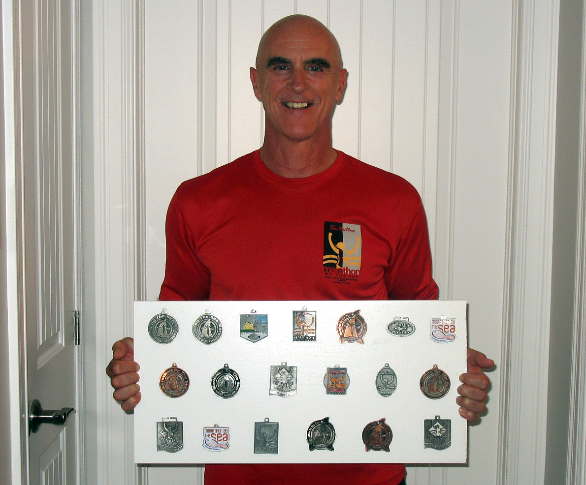 Pete McHugh shows off his collection of medals he has earned in running the previous 19 editions of the Marathon by the Sea. He is registered to run the 12km race in this year’s 20th anniversary running of the race on August 10.